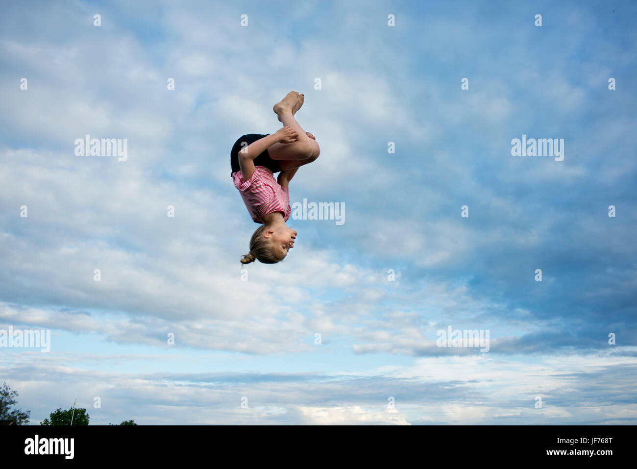 Mädchen tun Salto mitten in der Luft Stockfoto
