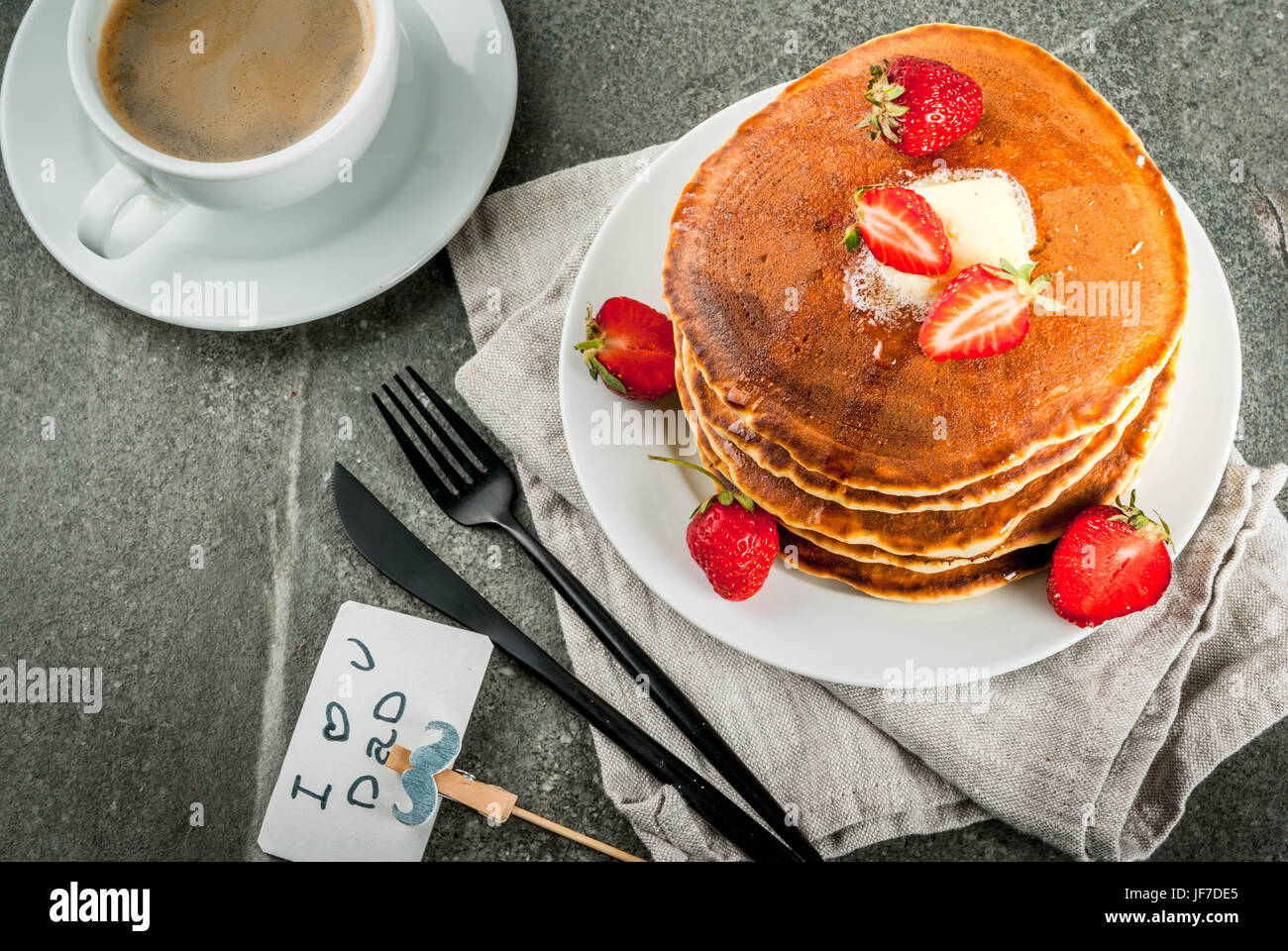 Vatertag feiern. Frühstück. Die Idee zum herzhaften und leckeren Urlaub Frühstück: Pfannkuchen mit Butter, Ahornsirup und frischen Erdbeeren, wi Stockfoto