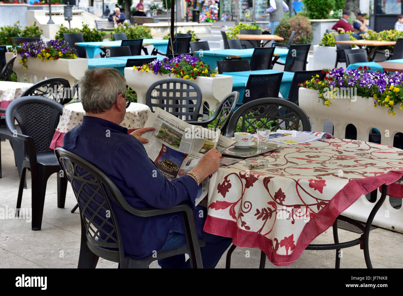 Mann sitzt allein am Tisch im Restaurant lesen Zeitung, Italien Stockfoto