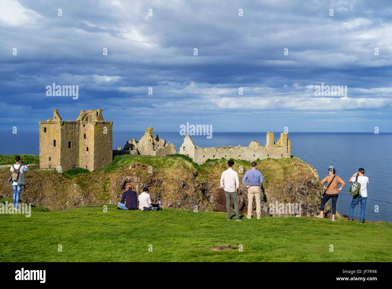 Touristen, die gerne am Dunnottar Castle, zerstörten mittelalterlichen Festung in der Nähe von Stonehaven auf Klippe entlang der Nordsee Küste, Aberdeenshire, Schottland, UK Stockfoto