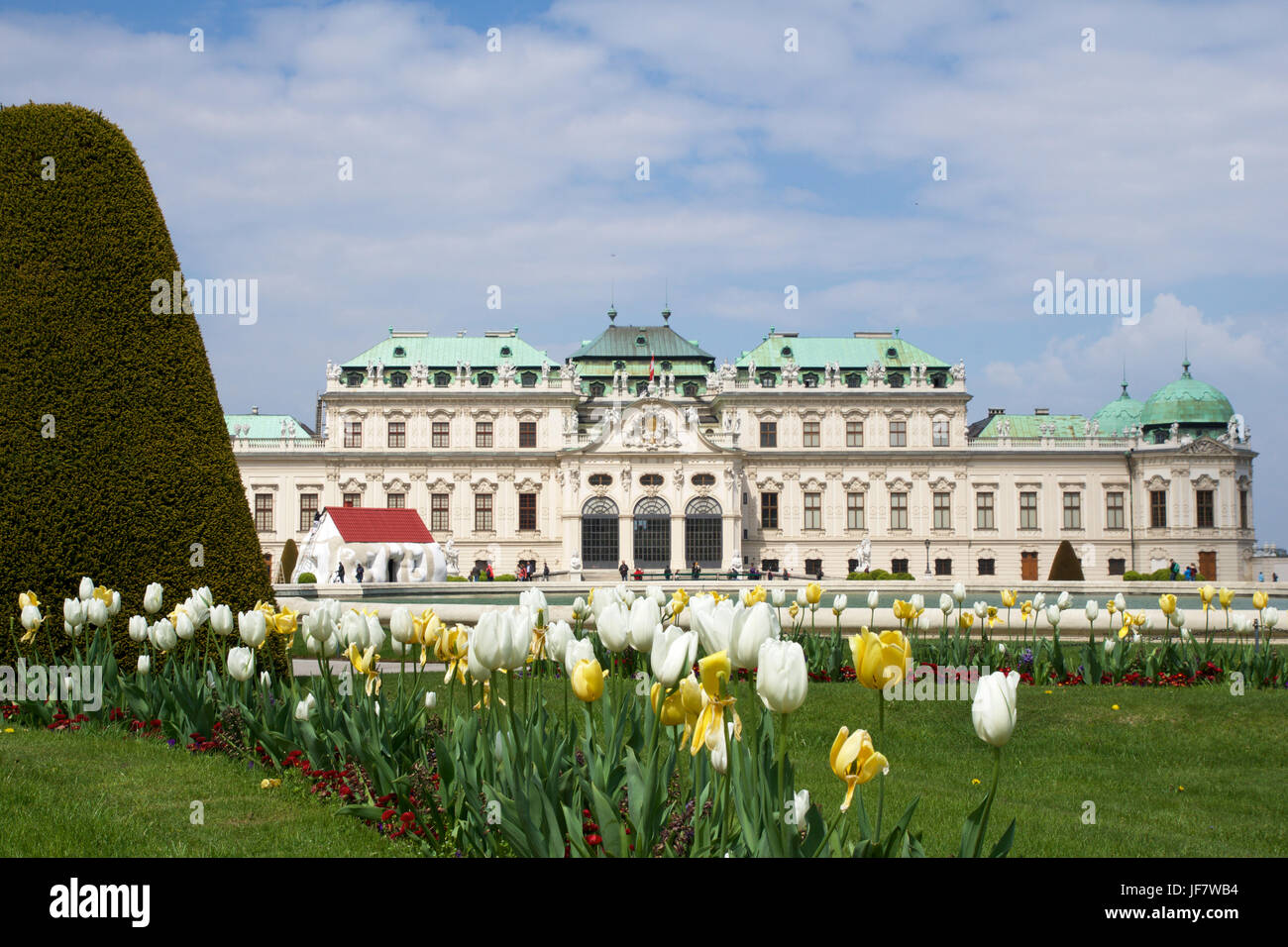 Wien, Österreich - 29. April 2017: Belvedere ist ein historischer Gebäudekomplex in Wien, bestehend aus zwei barocke Paläste der oberen und unteren Belvedere, die Orangerie und der Prunkstall. Bunte Tulpen im Vordergrund Stockfoto