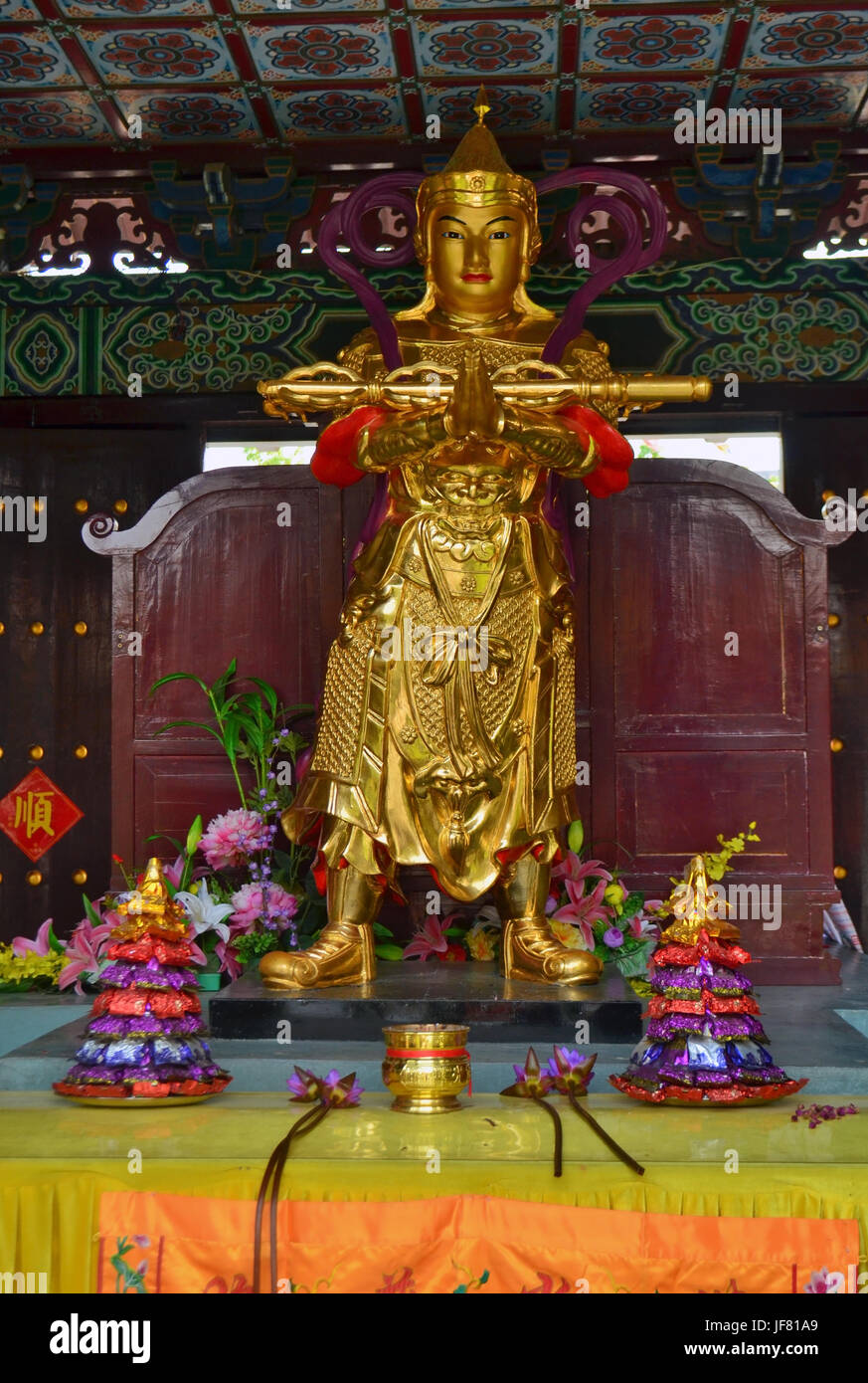 Goldene Statue und Angebote in traditionellen chinesischen buddhistischen Tempel in Lumbini, Nepal Stockfoto
