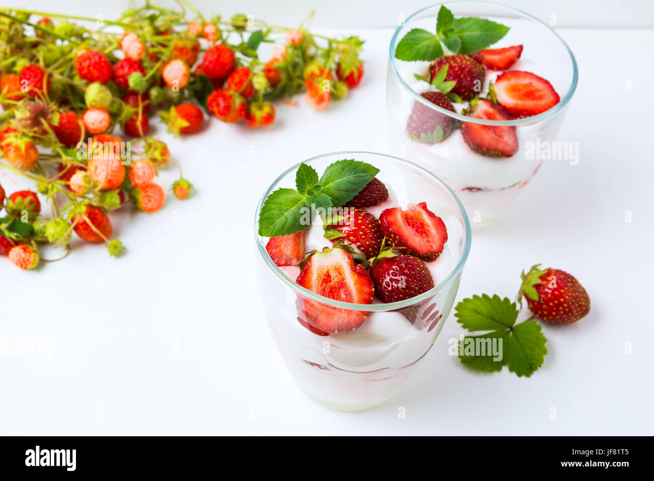Sommer geschichteten Eis Dessert und wilde Erdbeere Zweig auf dem weißen Hintergrund. Stockfoto