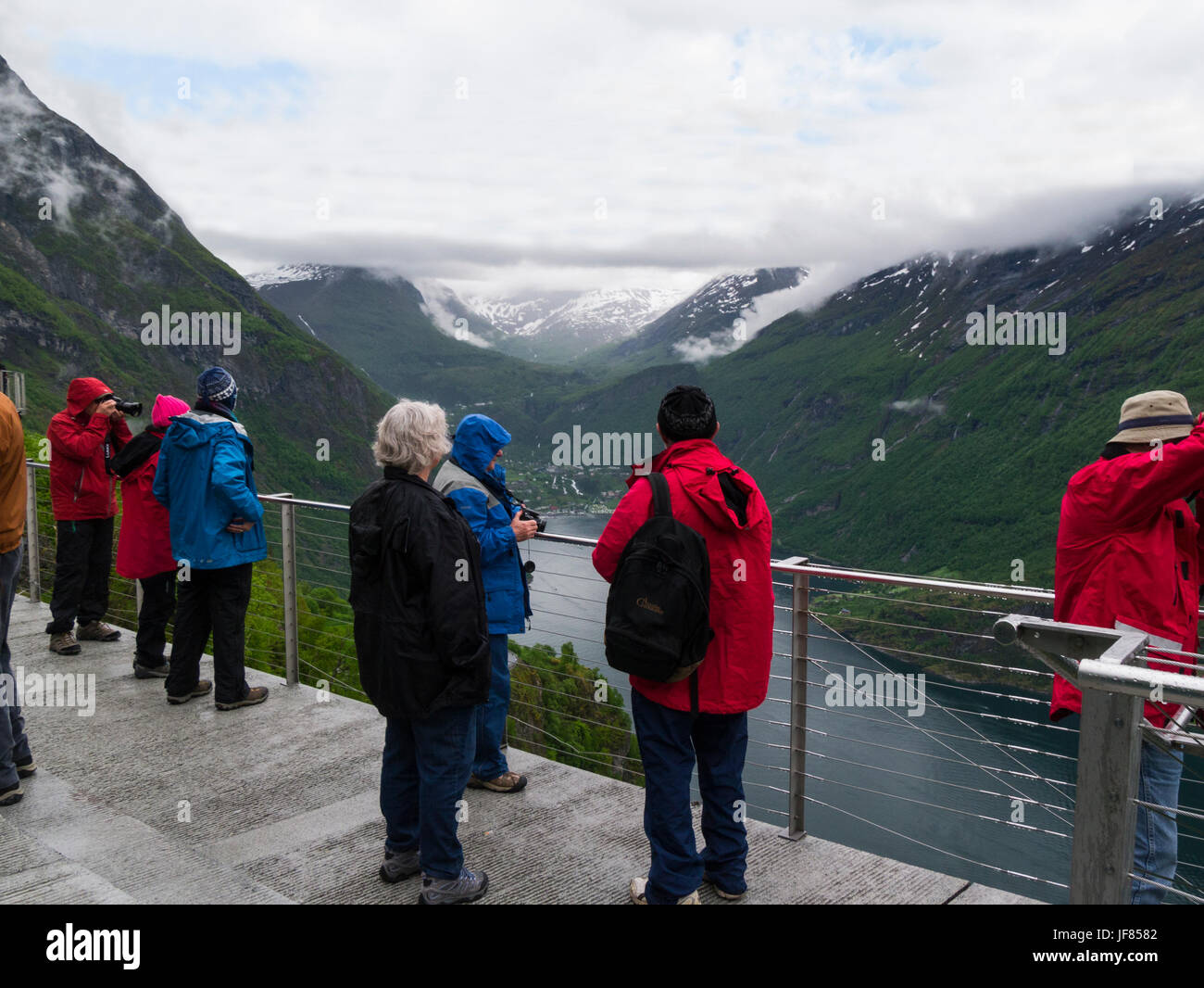 Touristen an Eagle Road Aussichtspunkt Blick auf Geirangerfjord an einem bewölkten Tag Sunnmøre Region Møre Og Romsdal Grafschaft Norwegens Stockfoto