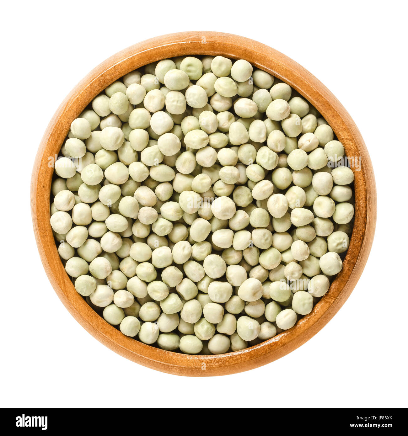 Getrocknete Erbsen in Holzschale. Kleine leichte grüne kugelförmige Samen aus den Schoten von Pisum Sativum, verwendet als Gemüse oder für die Aussaat. Stockfoto