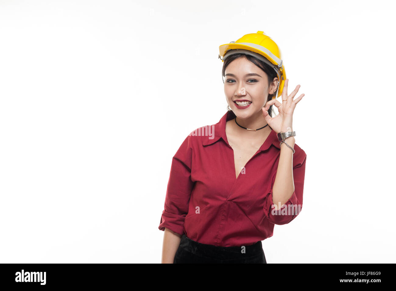 Asiatische Frau Ingenieur in rotem Hemd und gelbe Schutzkappe macht Ordnung handeln. Menschen Gestikulieren in Geschäfts- und Enginerring Konzept Stockfoto
