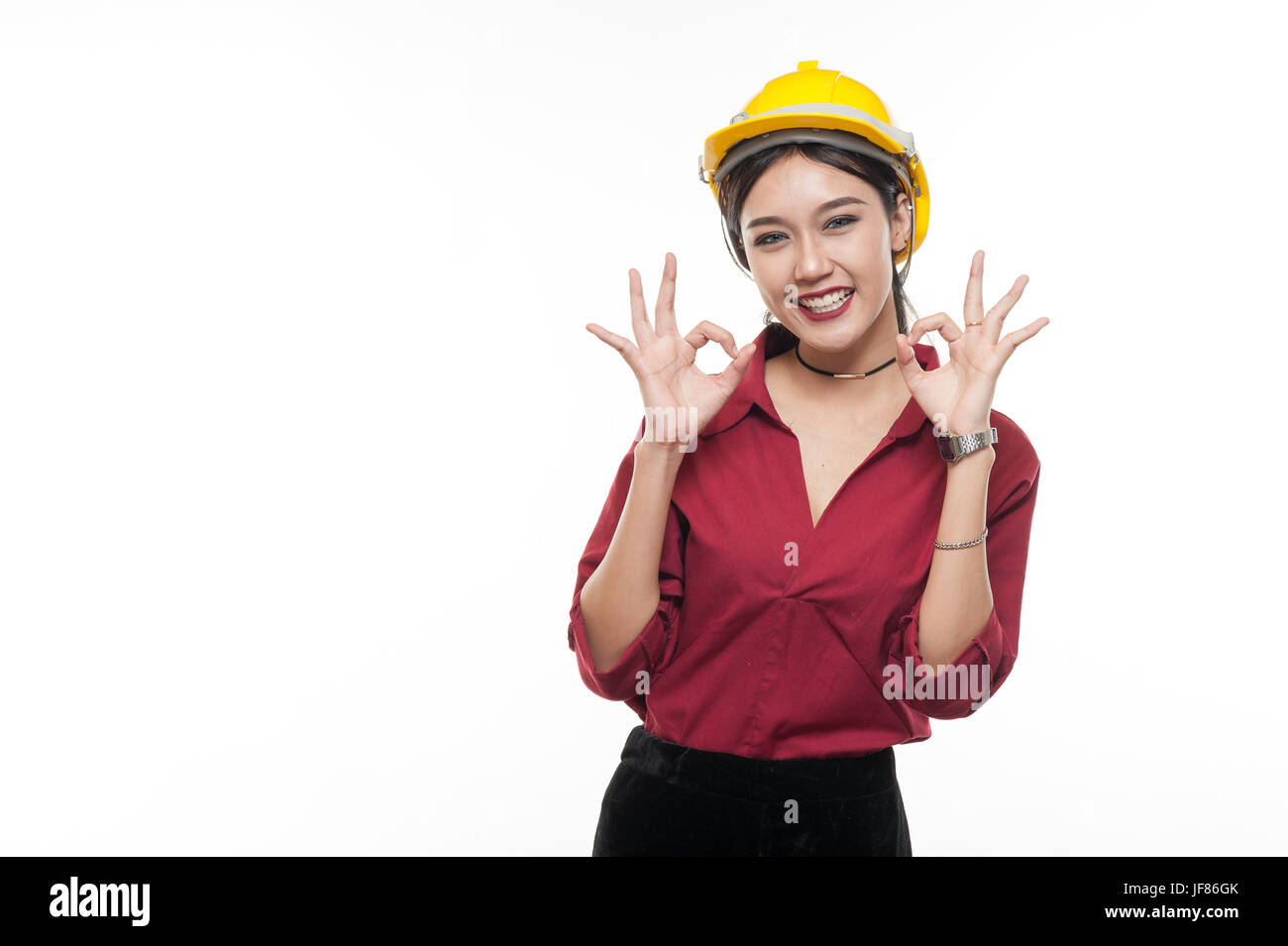 Asiatische Frau Ingenieur in rotem Hemd und gelbe Schutzkappe macht Ordnung handeln. Menschen Gestikulieren in Geschäfts- und Enginerring Konzept Stockfoto