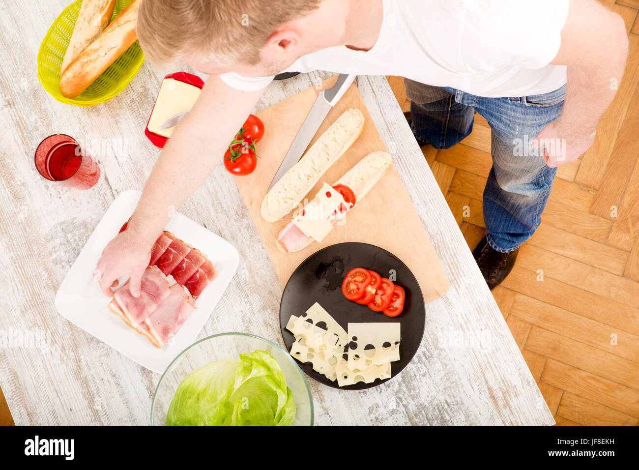 Junger Mann bereitet einen Sandwich Stockfoto