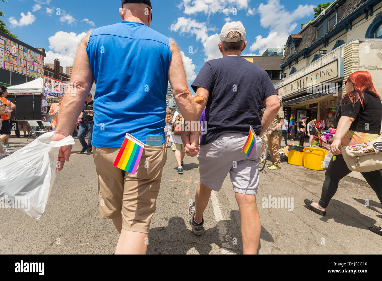 Toronto, CA - 24. Juni 2017: Gay paar Hand in Hand und Fuß in der Church Street im Gay Village. Stockfoto