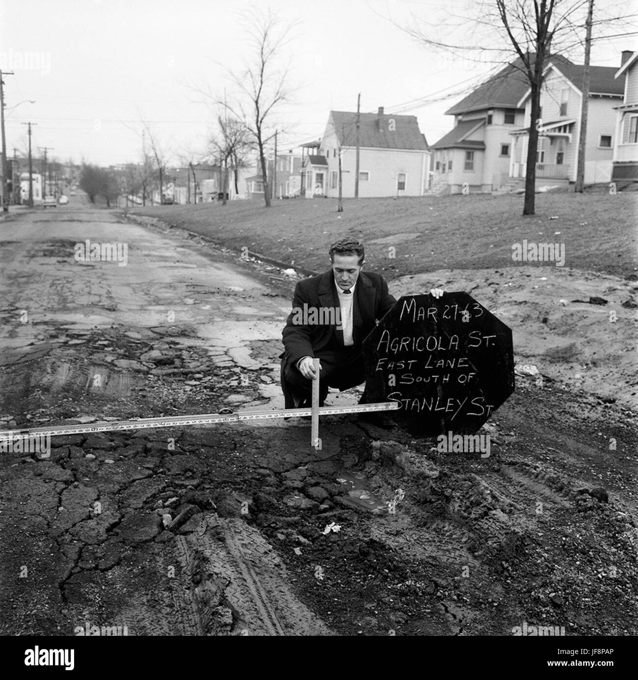 Eine Vintage-Fotografie, die Arbeiter beim Messen von Schlaglöchern auf der Agricola Street in Halifax dokumentiert und die kommunalen Instandhaltungsarbeiten Mitte des 20. Jahrhunderts widerspiegelt. Stockfoto
