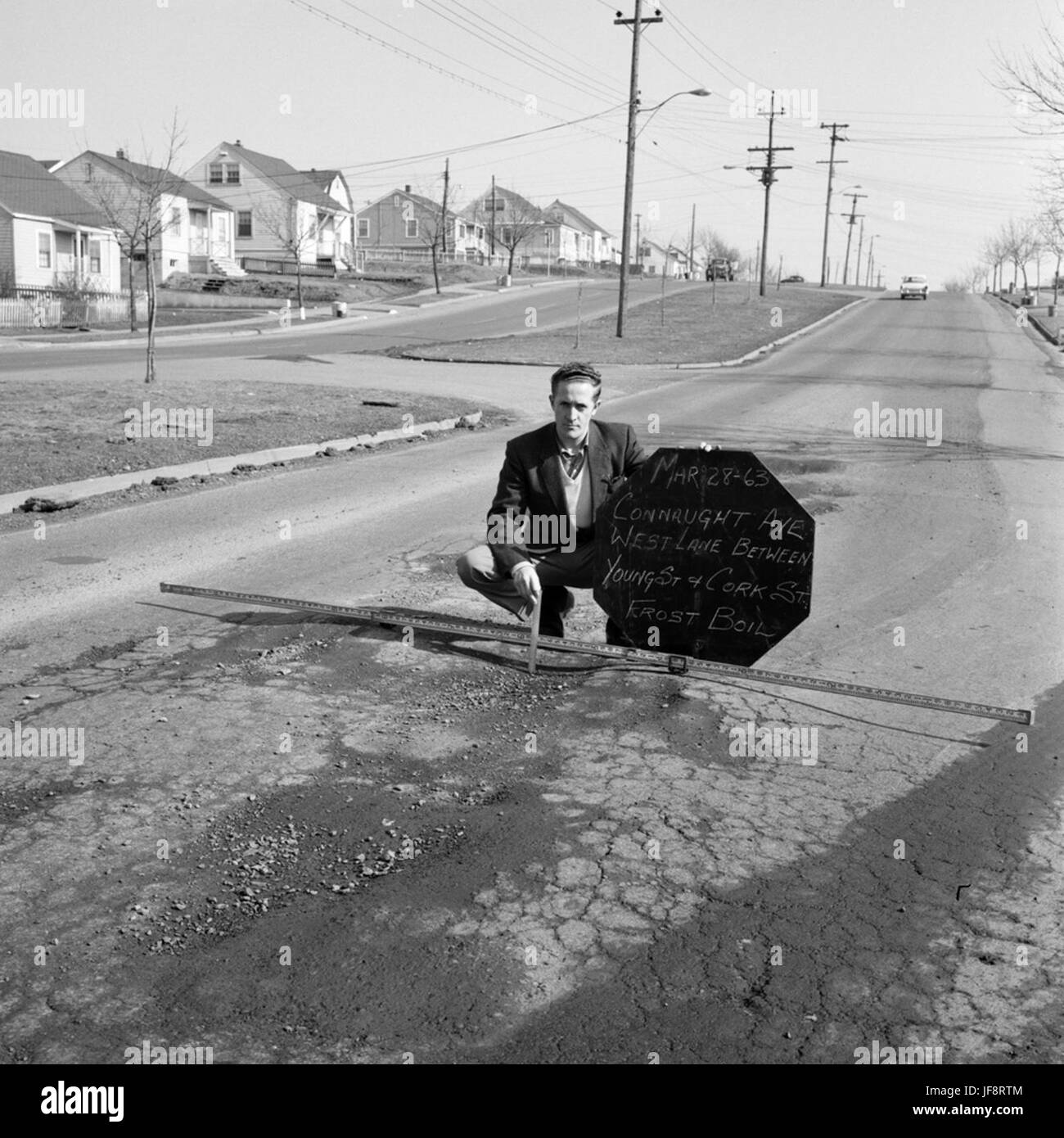 Eine Fotografie, die kommunale Arbeiter beim Messen von Schlaglöchern auf der Connaught Avenue in Halifax, Kanada, dokumentiert und die Instandhaltungsarbeiten der Infrastruktur in der Stadtentwicklung des frühen 20. Jahrhunderts darstellt. Stockfoto