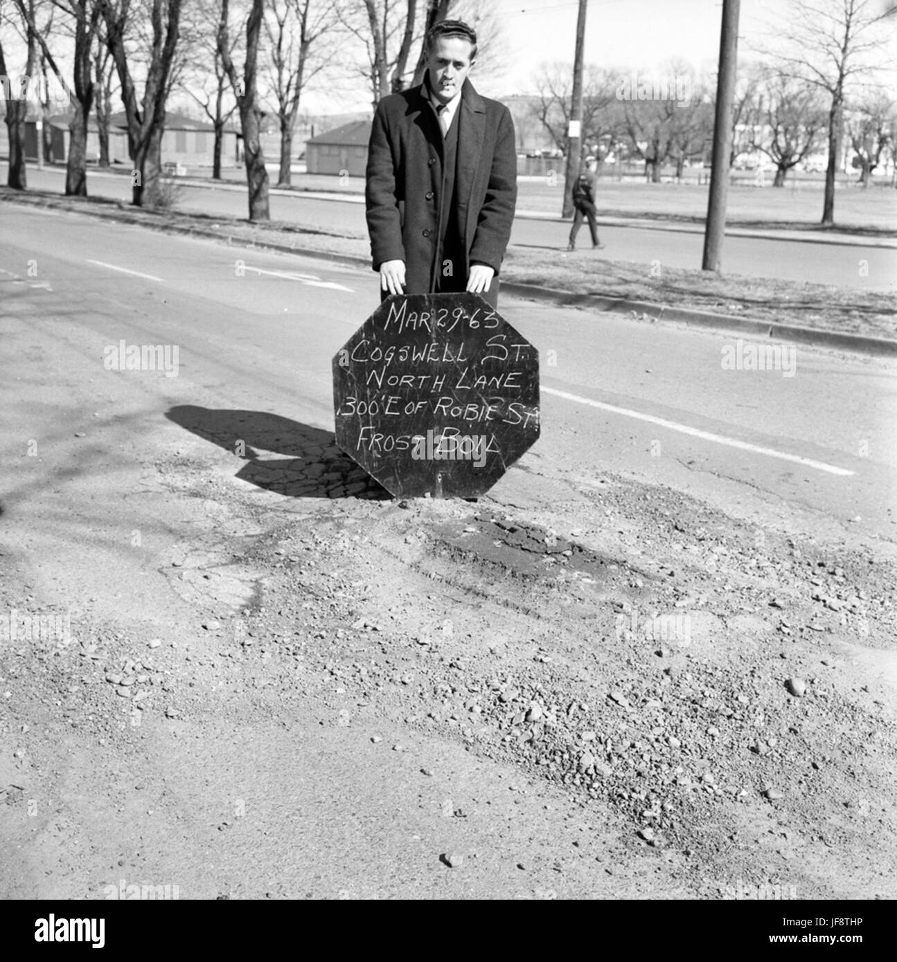 Ein Foto, auf dem kommunale Arbeiter in Halifax, Nova Scotia, bei der Messung von Schlaglöchern auf der Cogswell Street festgehalten werden und die frühen Arbeiten an der städtischen Infrastruktur veranschaulicht werden. Stockfoto