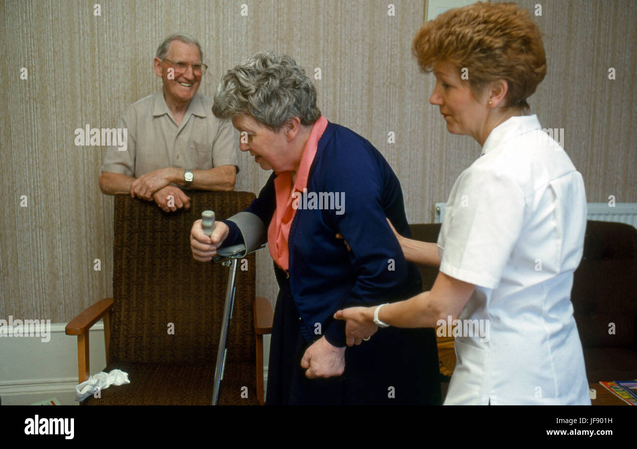 Gesundheit Besucher besuchen ältere Frau mit Arthritis helfen sie mit ihrer Krücke Stockfoto