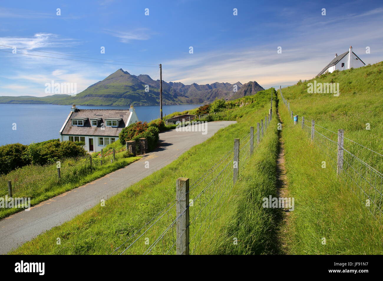 ISLE OF SKYE, UK - 20. Juni 2017: Blick auf der Black Cuillin Gebirge über Loch Scavaig vom Küstenweg in der Nähe von Elgol mit traditionellen Haus Stockfoto