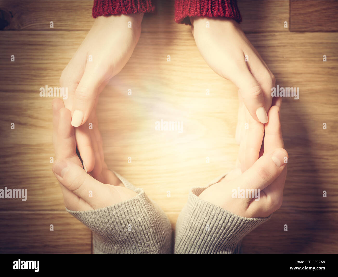 Frau und Mann Circle mit Händen machen. Warmes Licht im Inneren, Begriff der Energie, Schutz, Liebe usw.. Stockfoto