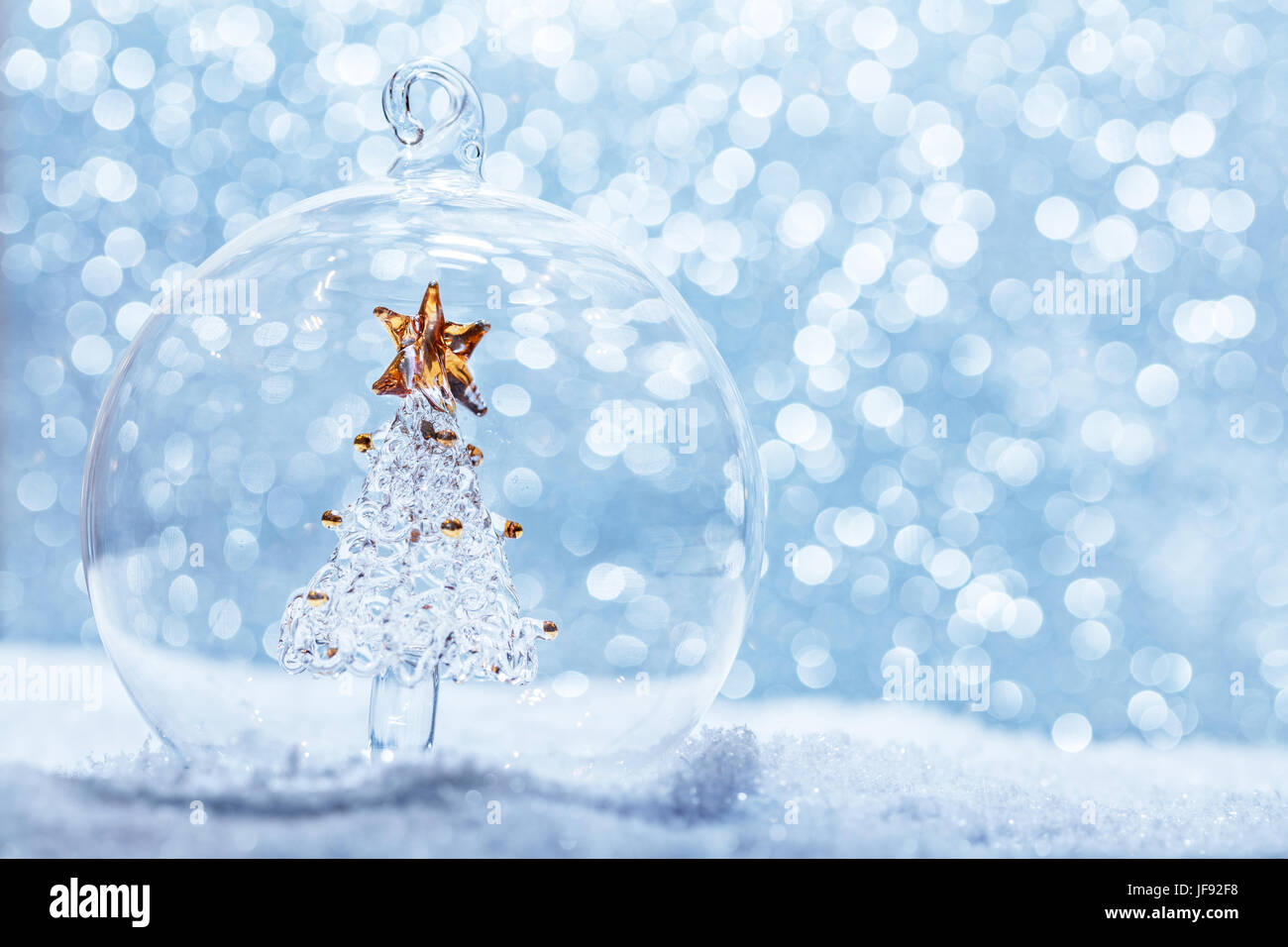 Weihnachtskugel Glas mit Kristall-Struktur im Inneren im Schnee. Glitter-Hintergrund. Stockfoto