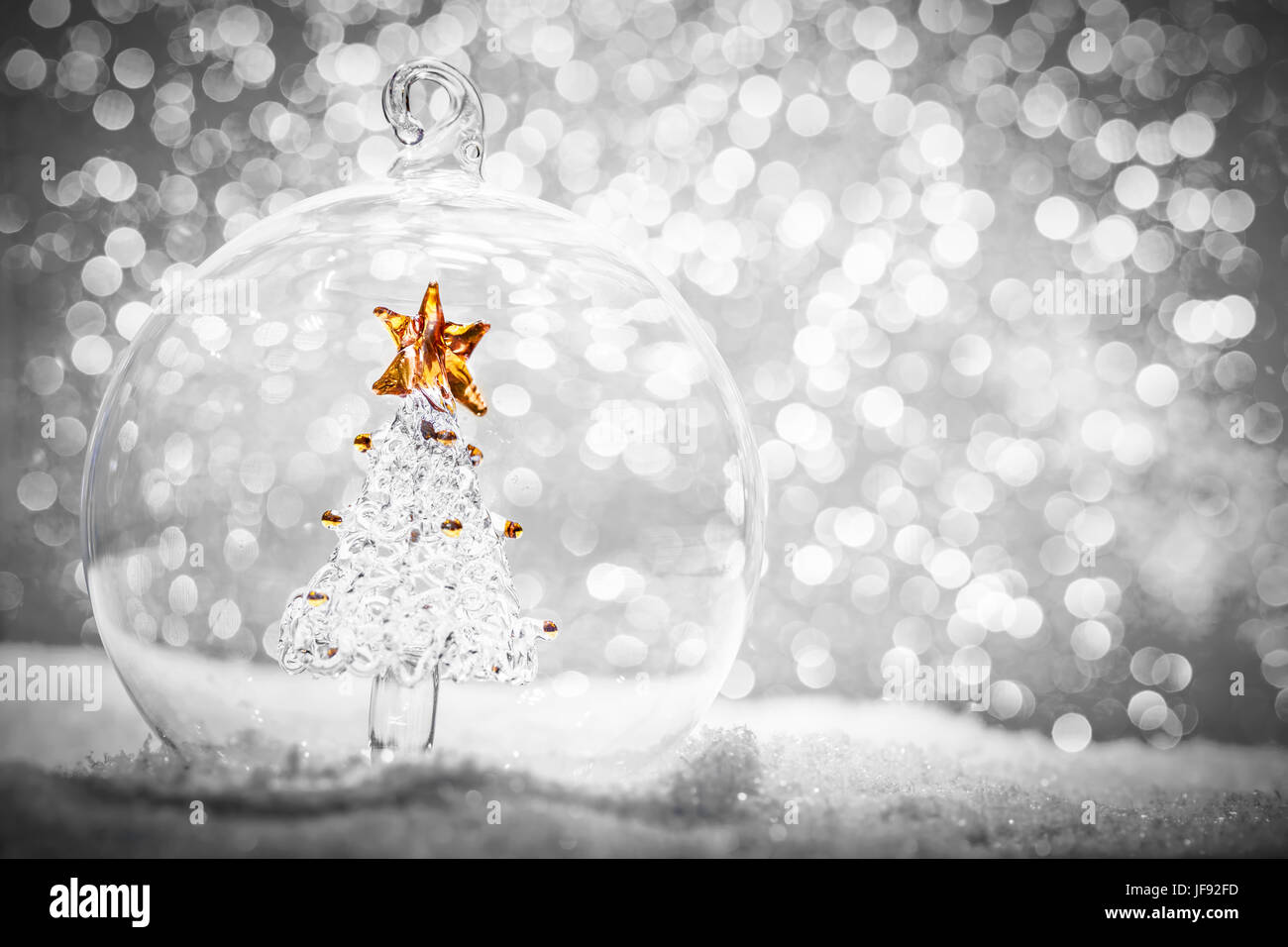 Weihnachtskugel Glas mit Kristall-Struktur im Inneren im Schnee. Glitter-Hintergrund. Stockfoto
