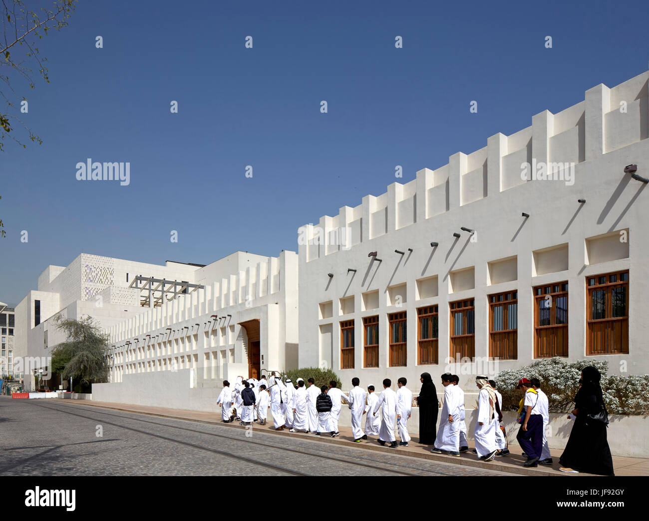Schülerinnen und Schüler zu Fuß in Richtung Eingang. Bin Jelmood Haus, Doha, Katar. Architekt: John Macaslan und Partner, 2017. Stockfoto