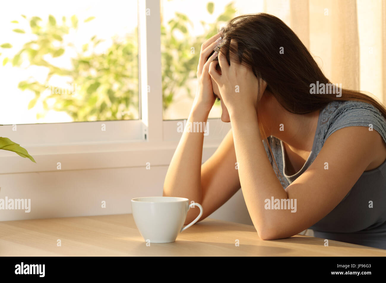 Einzige traurige Frau bedeckte Gesicht sitzen in einer Tabelle zu Hause Stockfoto