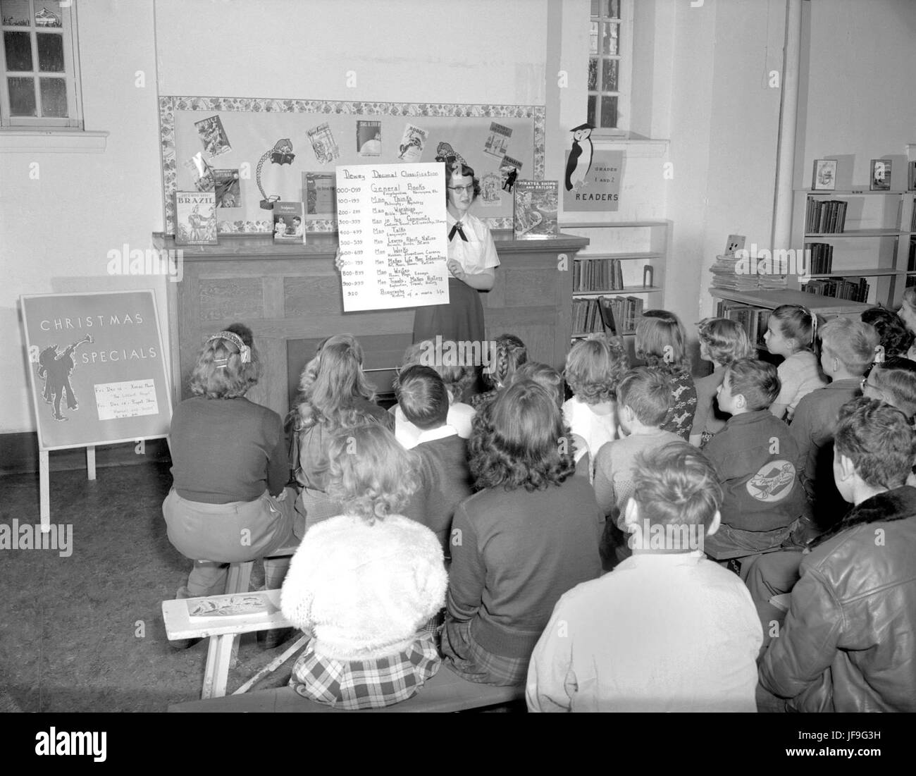 Eine Bildfotografie, die einen Bibliothekar aus Edmonton zeigt, der Studenten das Dewey Decimal System unterrichtet und das Wachstum von Bibliotheken und Bildung im 20. Jahrhundert widerspiegelt. Stockfoto