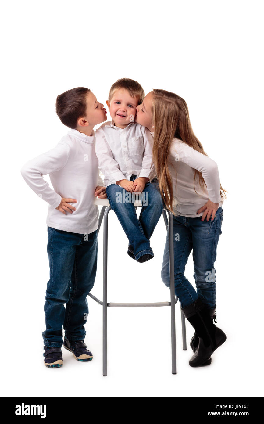 Glückliche Familie. Jungen und Mädchen, die ihren kleinen Bruder einen Kuss zu geben. Isoliert auf weißem Hintergrund Stockfoto