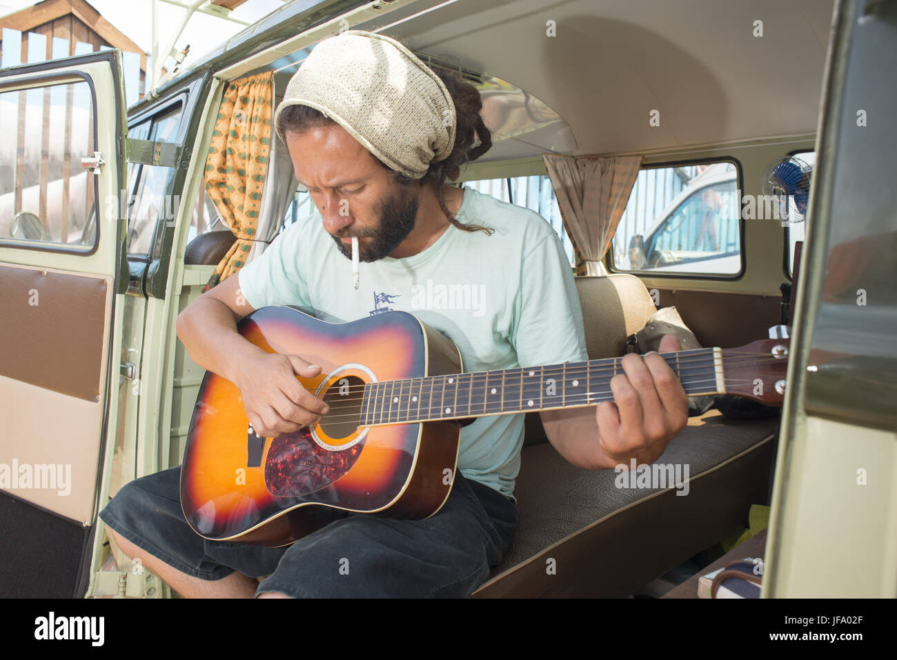 Hippie mit Gitarre in alten Van Stockfoto
