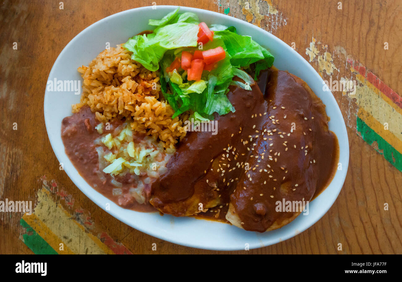 Enchiladas Maulwurf mit gebackenen Bohnen, brauner Reis und Salat Stockfoto