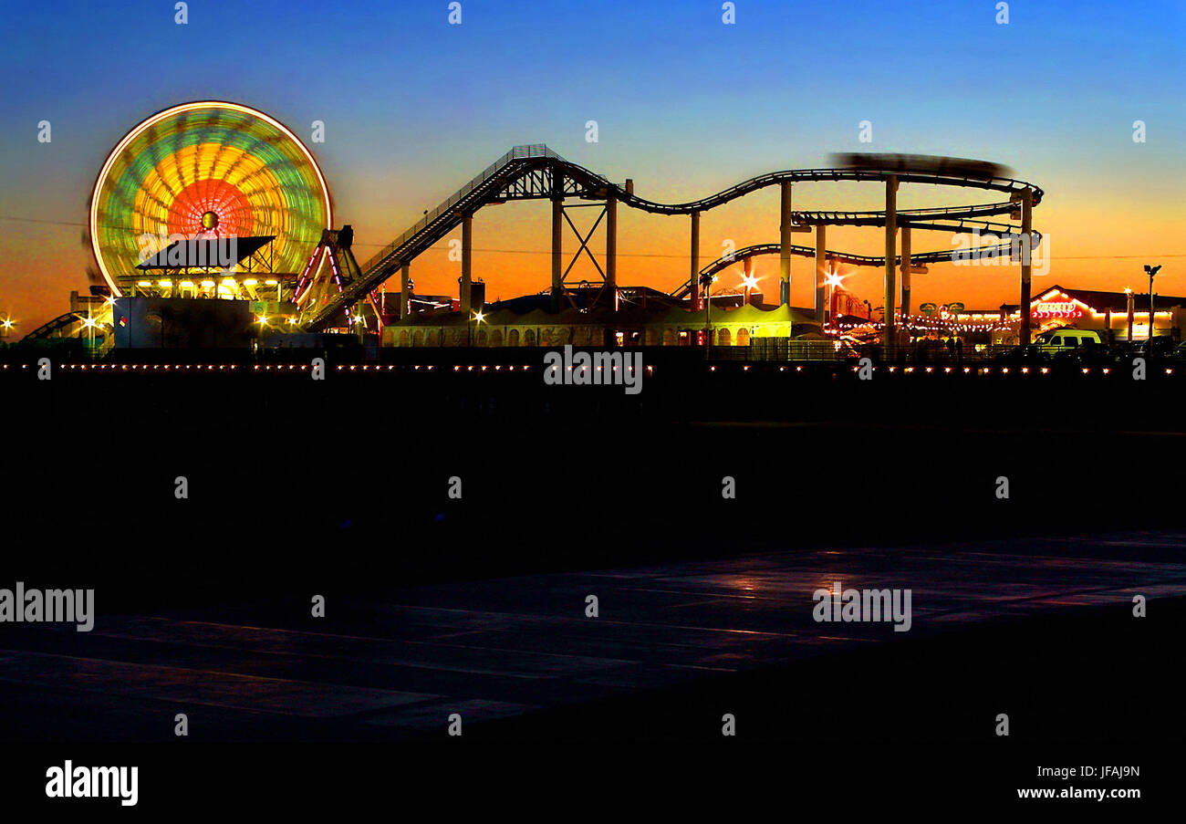 Santa Monica, Kalifornien, USA. 14. Juni 2002. Sonnenuntergang beleuchtet die Neonlichter und Fahrten über die Santa Monica Pier in Kalifornien über ein Jahrhundert alt jetzt mit Blue Streak Racer Holzachterbahn, original Karussell, die Peitsche, Karussells, Wurlitzer Orgeln und einem Funhouse. Bildnachweis: L.e. Baskow/ZUMA Draht/Alamy Live-Nachrichten Stockfoto