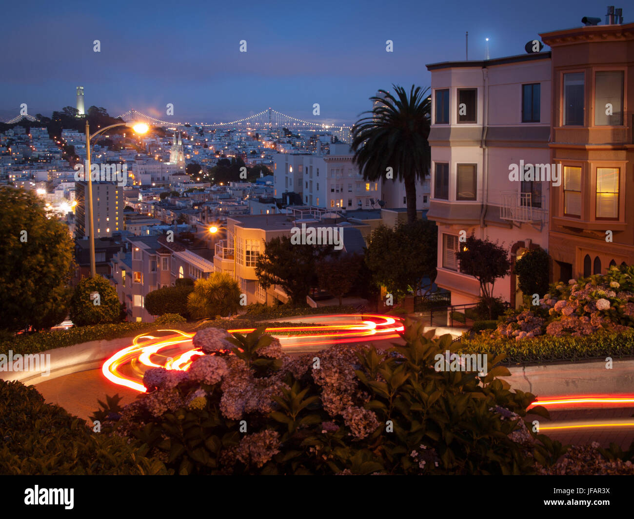 Lombard Street, der "krummste Straße der Welt", in der Nacht, mit Lichtspuren von vorbeifahrenden Autos, in San Francisco, Kalifornien. Stockfoto