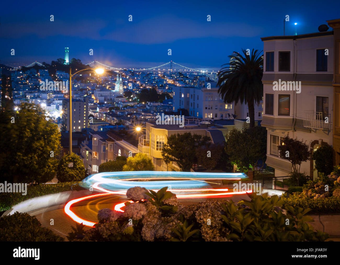 Lombard Street, der "krummste Straße der Welt", in der Nacht, mit Lichtspuren von vorbeifahrenden Autos, in San Francisco, Kalifornien. Stockfoto