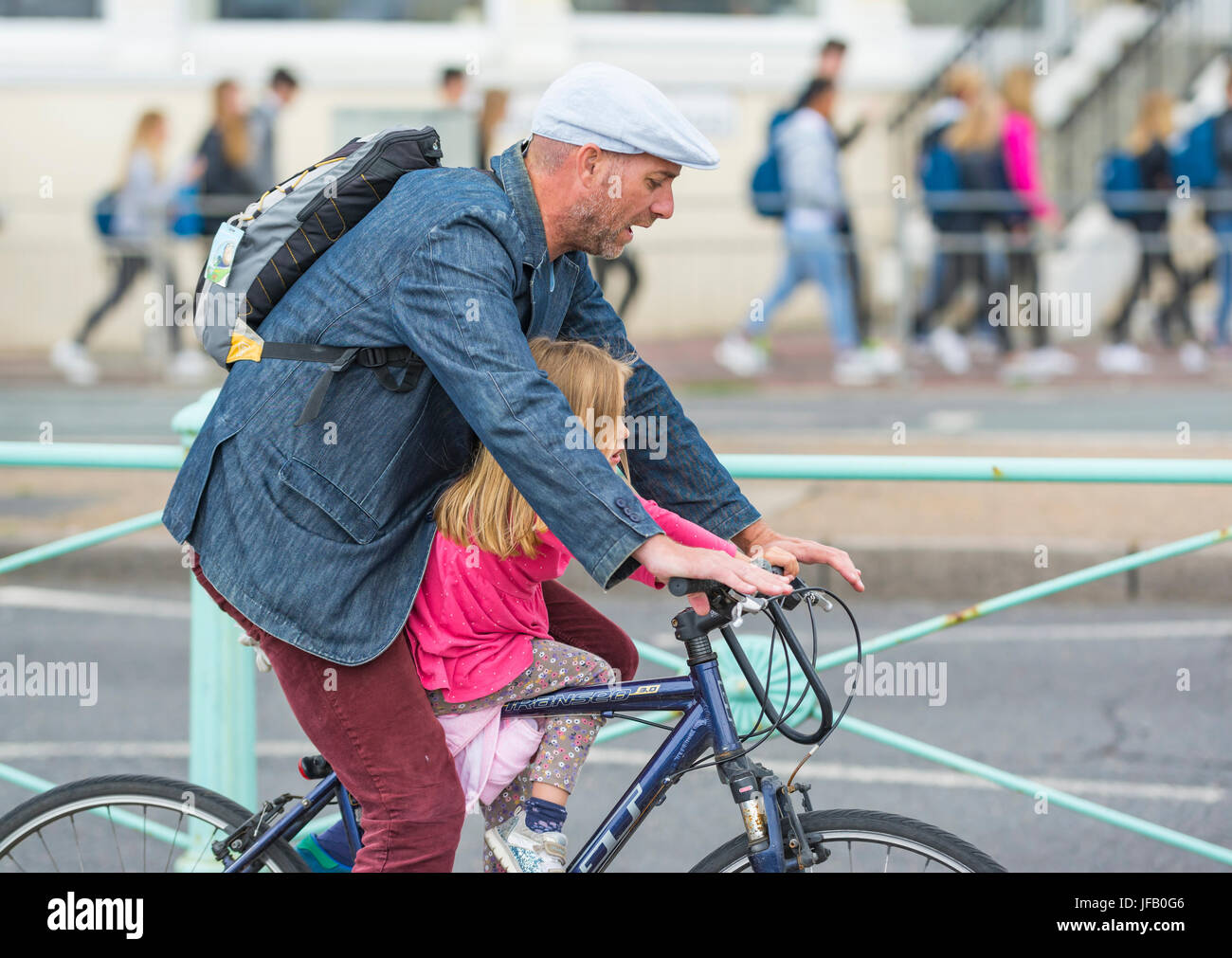 Radfahrer ohne Helm mit einem Kind. Stockfoto