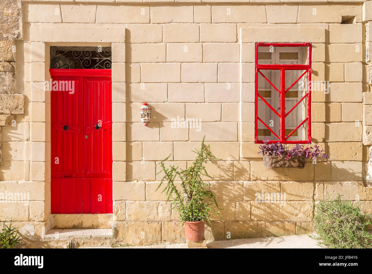 Senglea, Malta - traditionelle rote Tür und Fenster eines alten maltesischen Hauses in Senglea an einem sonnigen Sommertag Stockfoto