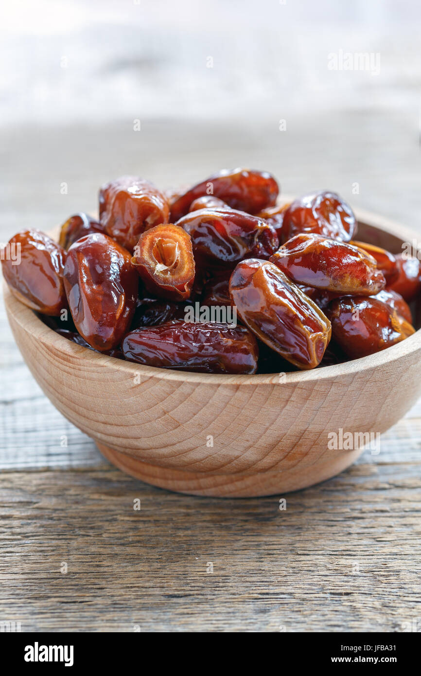 Hölzerne Schüssel mit getrockneten Datum Obst. Stockfoto