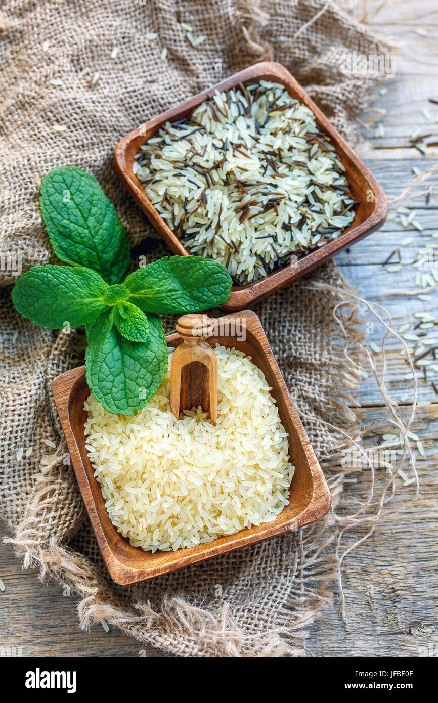 Verschiedene Sorten von Reis in hölzernen Schüsseln. Stockfoto
