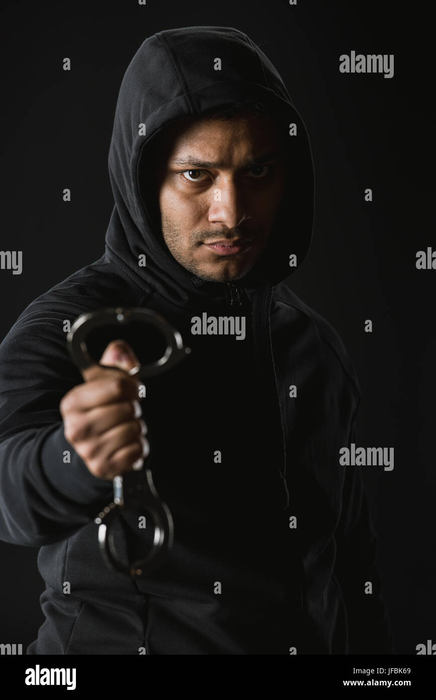junge afrikanische amerikanische Räuber im Zoodie und Handschellen isoliert auf schwarz Stockfoto