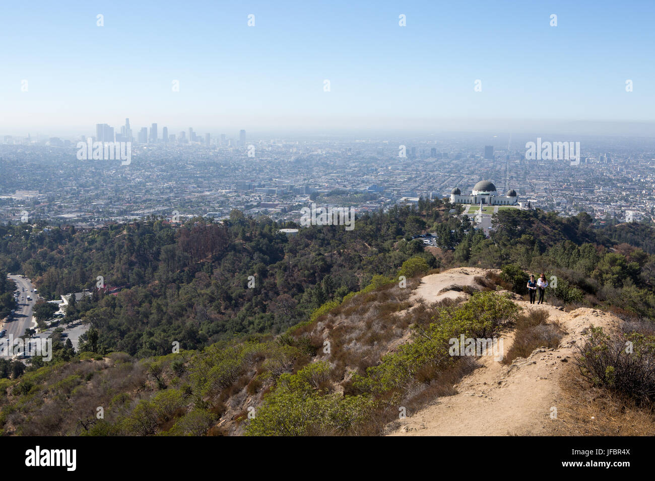 Wanderer folgen einem Pfad in der Nähe des Griffith Observatorium. Verunreinigung der Luft hängt über Los Angeles. Stockfoto