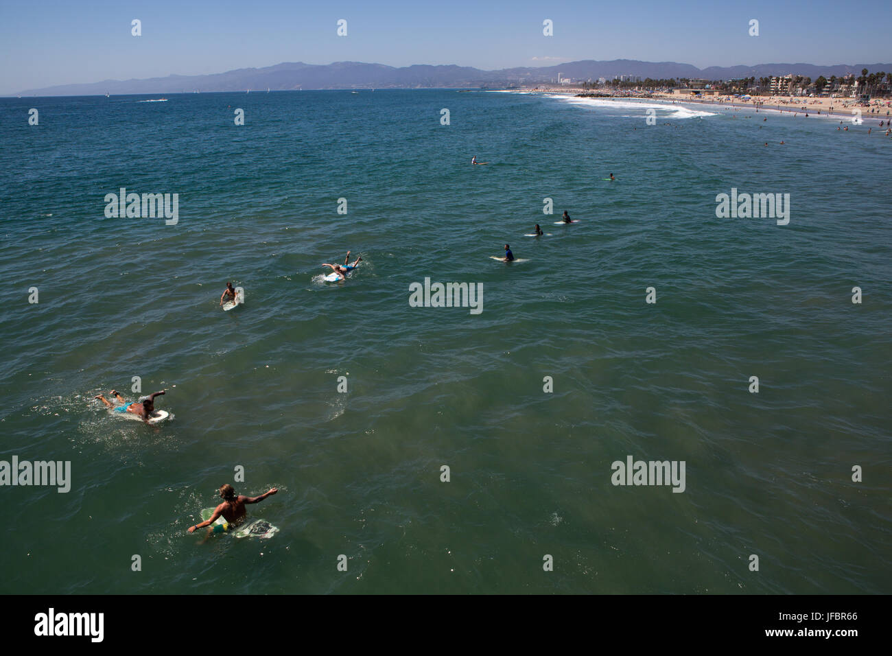Am Venice Beach, mehrere Surfer Paddel aus und für die nächste Welle warten. Stockfoto