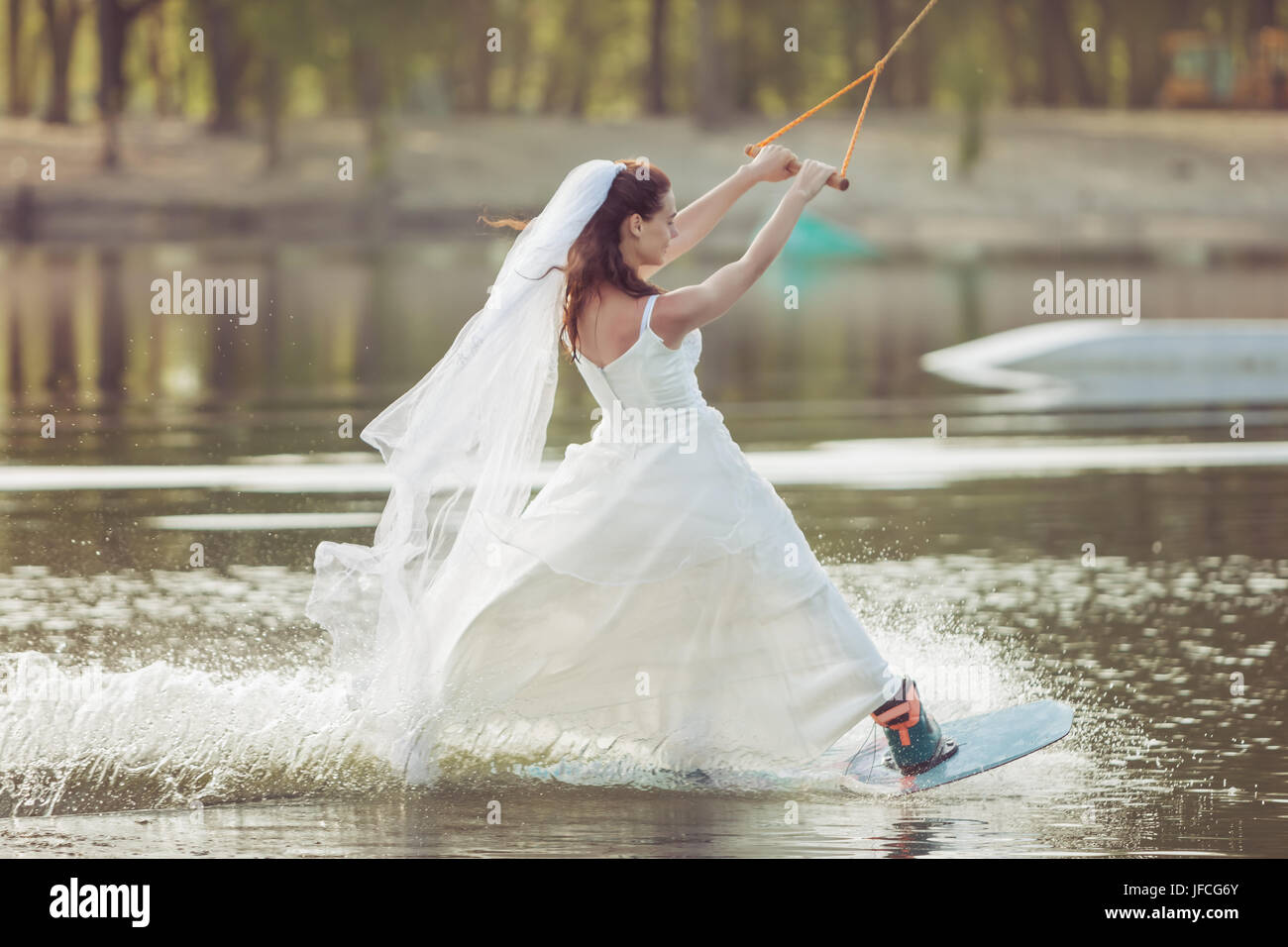 Braut Ein Hochzeitskleid Und Schleier Auf Dem Kopf Engagiert Sich Fur Extremsport Ist Sie Auf Einem Wakeboard Stockfotografie Alamy