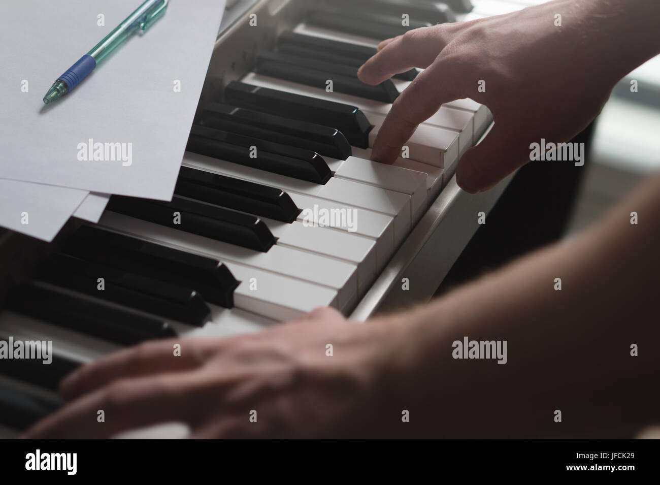 Klavierunterricht, coaching, Lehre oder Ausbildung Konzept. Talentierter Pianist zeigt Beispiel mit digitaler Musikinstrument. Intime und filmischen Blick. Stockfoto
