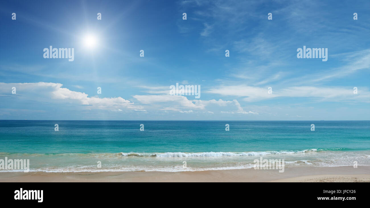 Sandstrand und Sonne am blauen Himmel Stockfoto