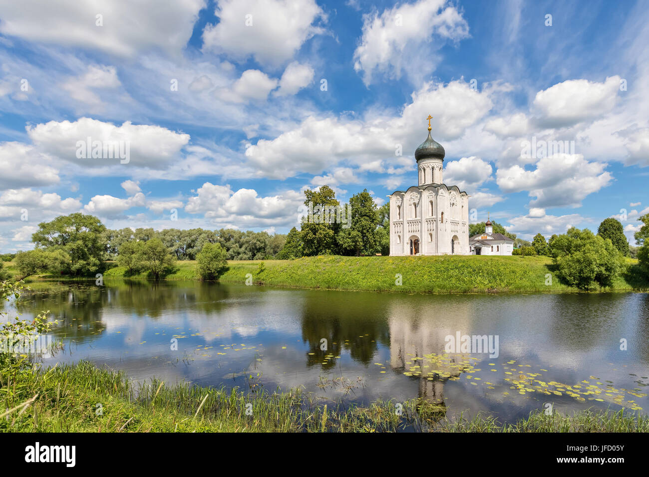 Kirche der Fürsprache an der Nerl in Wasser an einem sonnigen Tag und an den malerischen Wolken in Bogolyubovo, Vladimir oblast, Russland widerspiegelt Stockfoto