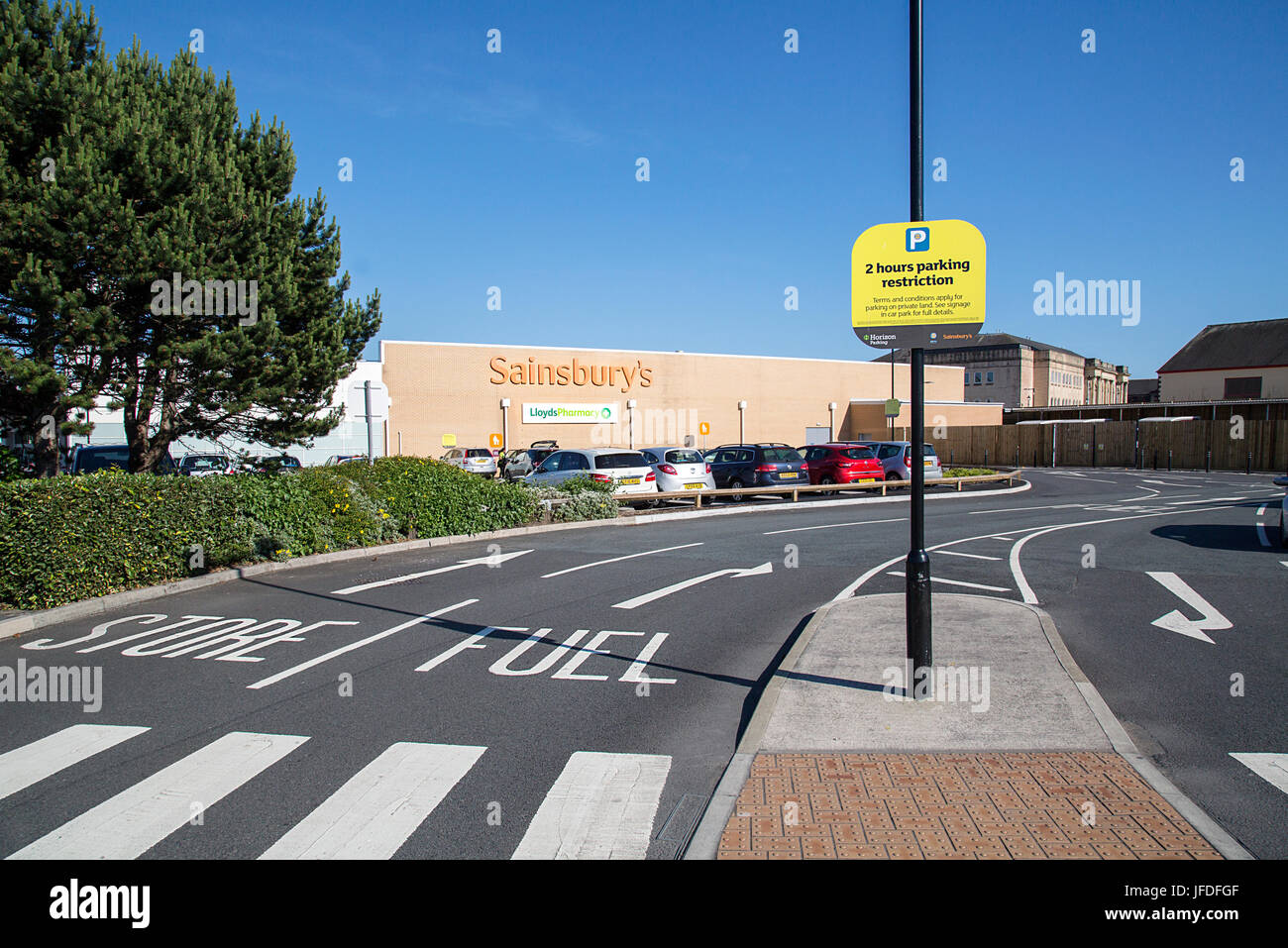 Sainsbury's Supermarkt Straße Eingang führt zu den Store oder eine Tankstelle. Sainsbury's sind eine britische besessene Supermarktkette. Stockfoto