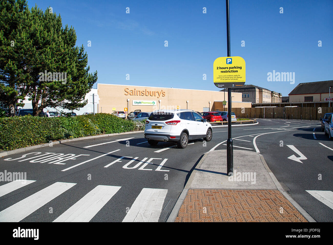 Sainsbury's Supermarkt Straße Eingang führt zu den Store oder eine Tankstelle. Sainsbury's sind eine britische besessene Supermarktkette. Stockfoto