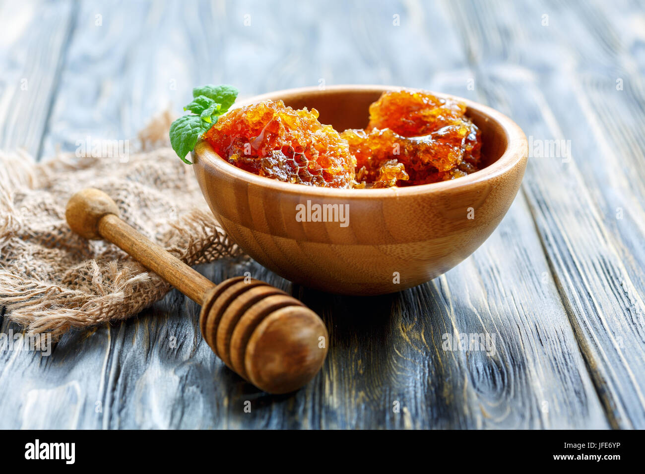 Hölzerne Schüssel mit Honig in den Kamm. Stockfoto