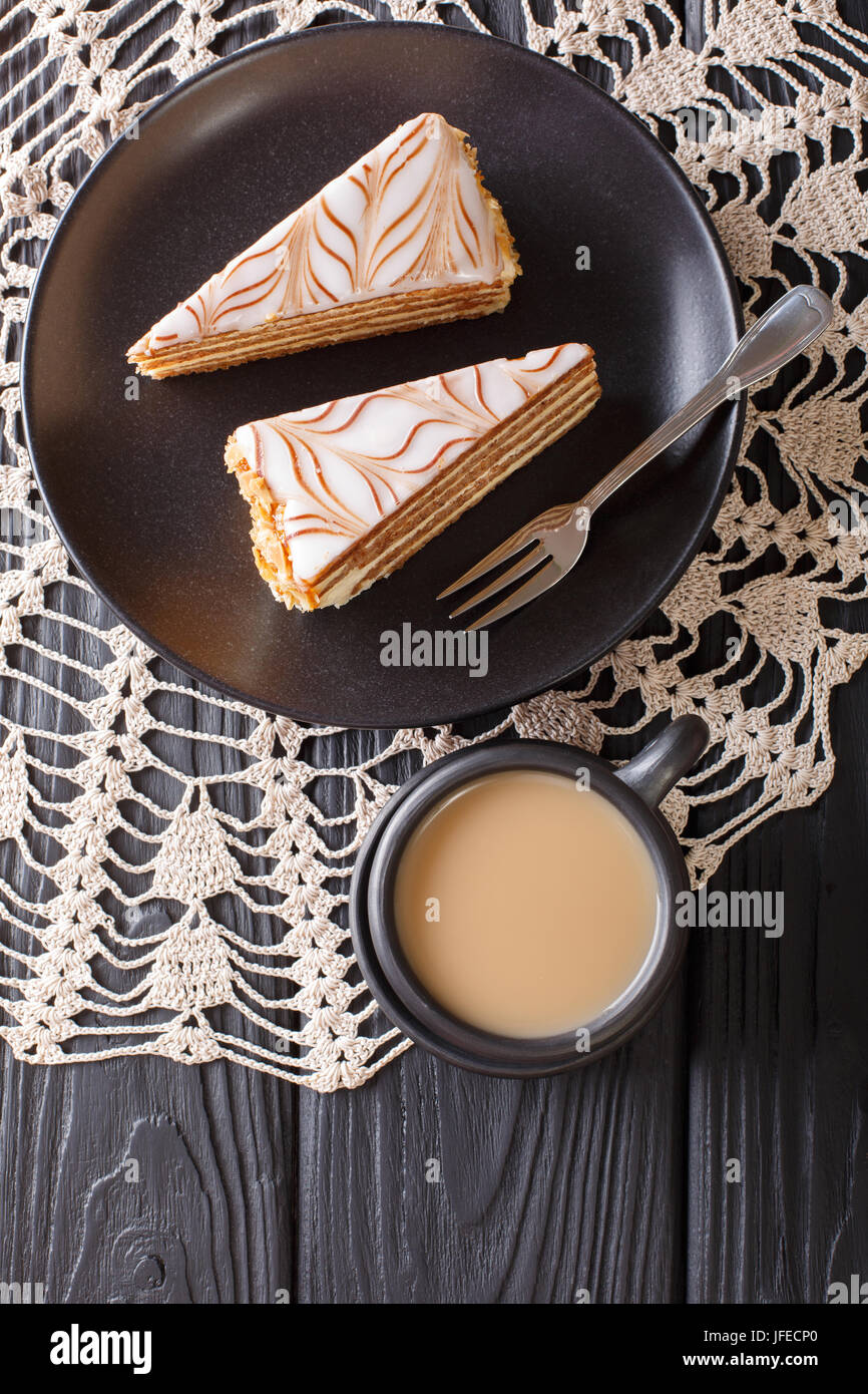 Die Torte von Esterhazy und Kaffee mit Milch Nahaufnahme auf dem Tisch. Vertikale Ansicht von oben Stockfoto