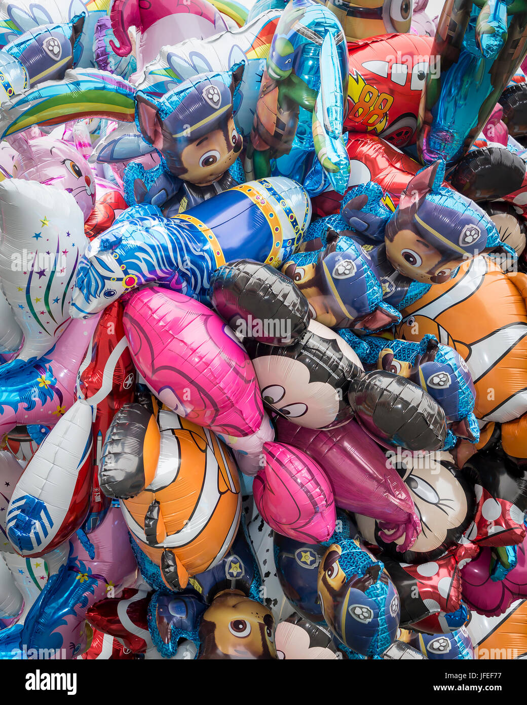 Haufen bunte Luftballons in verschiedenen Formen zum Verkauf auf der Straße Stockfoto