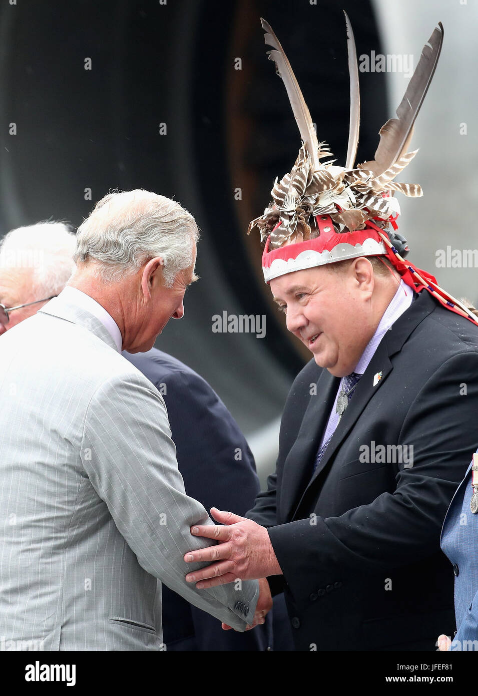 Der Prince Of Wales grüßt einen Mann in einem traditionellen Kopf-Stück, als er bei Canadian Forces Base Trenton in Quinte West, Ontario, im zweiten Tag ihres Besuchs nach Kanada ankommt. Stockfoto