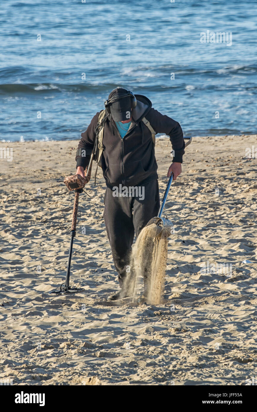 Ein Metalldetektor in den Sand am Strand mit dem Meer im Hintergrund im Hochformat vertikale Suche Stockfoto