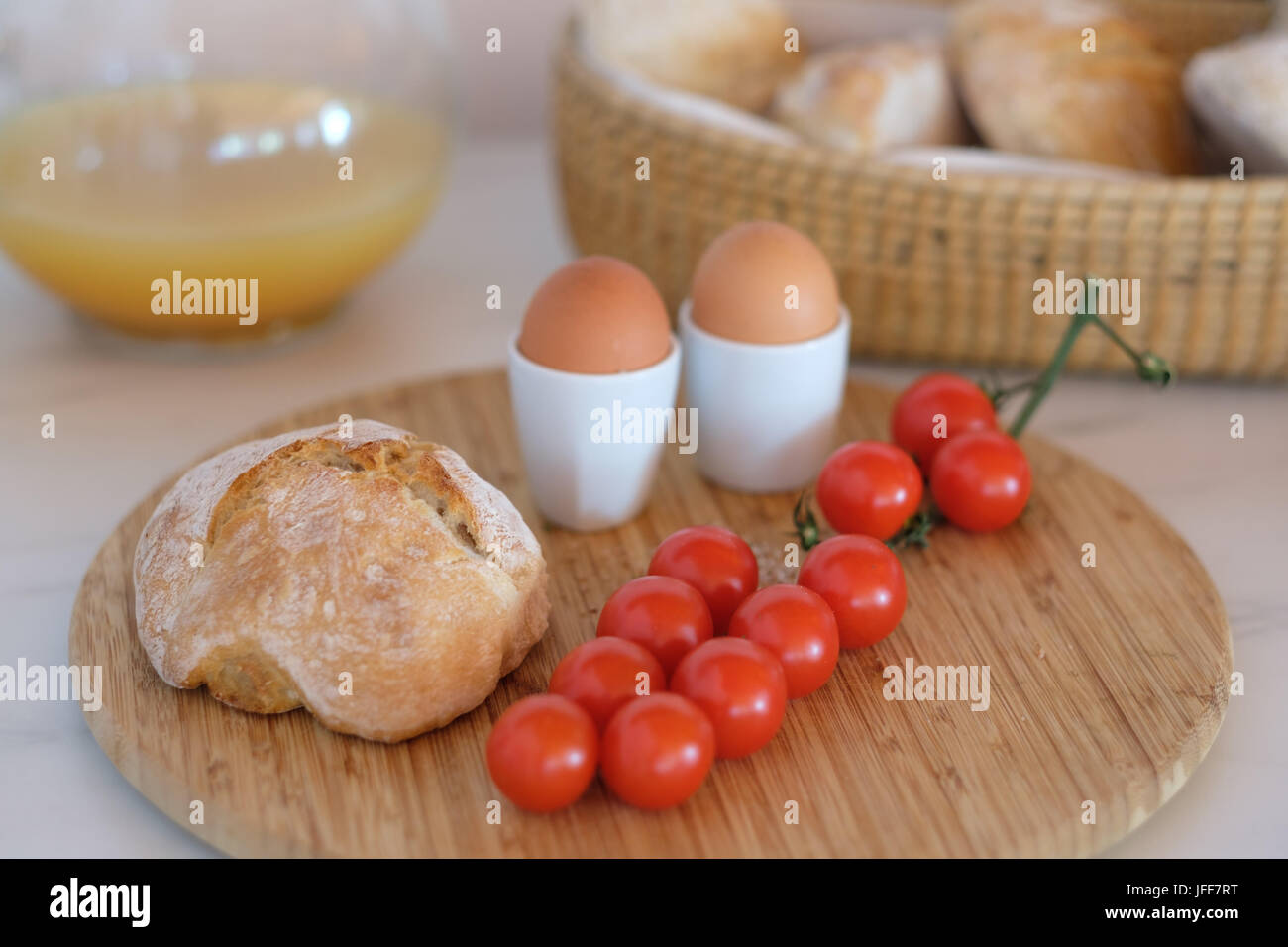 Gesundes Frühstück mit gekochten Eiern, Brot, Tomaten und Orangensaft Stockfoto