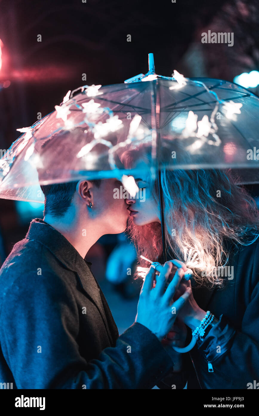 Mann und ein Mädchen küssen unter einem Regenschirm Stockfoto